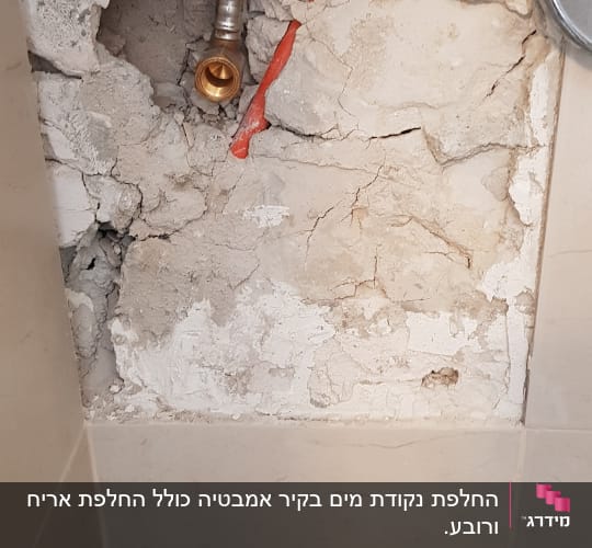 צינור מים חשוף בקיר שבור
